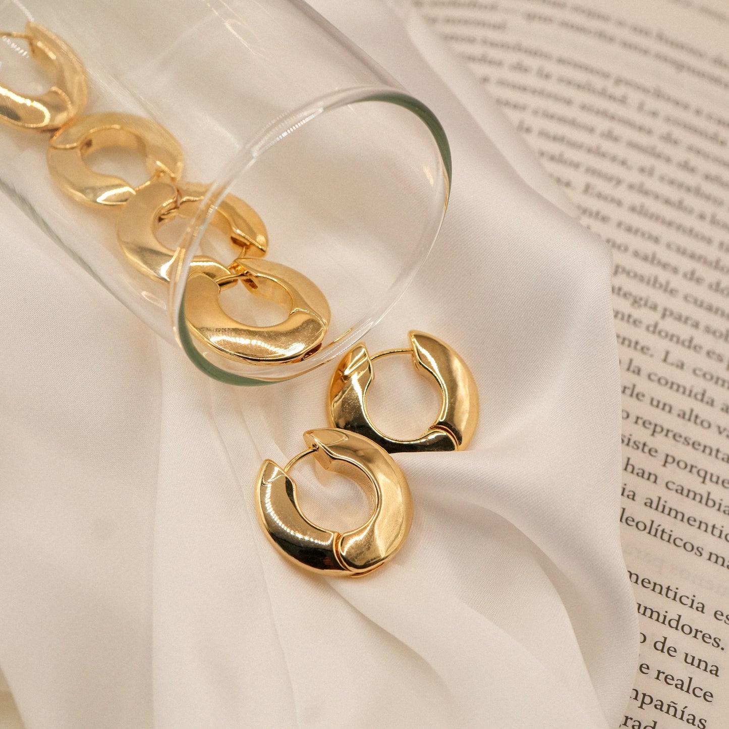 Aros Cyra vertidos desde una copa sobre un libro - Oasis Blanco